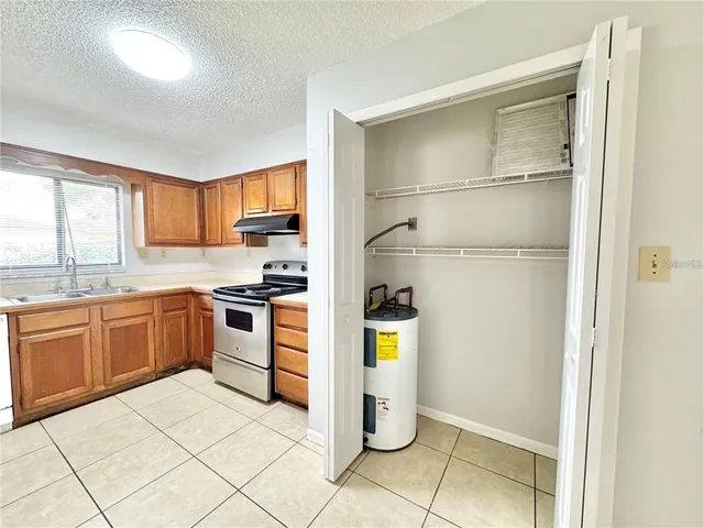 a large kitchen with a window and stainless steel appliances