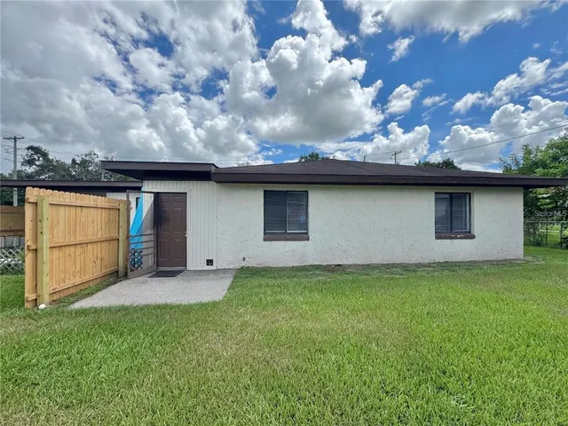 a yellow house with flower garden in front of it