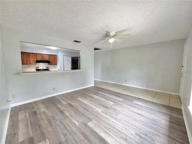 a view of a livingroom with wooden floor and a ceiling fan