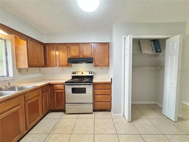 a kitchen with a stove sink and cabinets