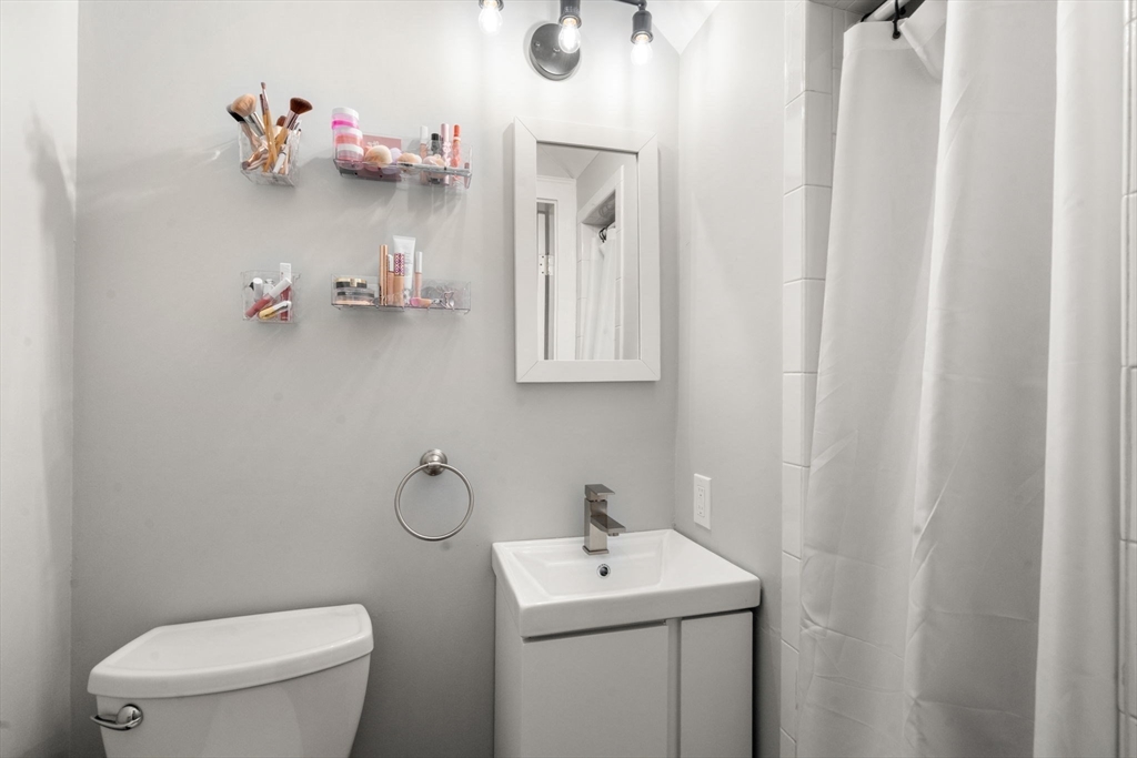 9 Dunton Road, Unit 9 Watertown, MA 02472 - Photo 18 of 39 a bathroom with a toilet sink and mirror