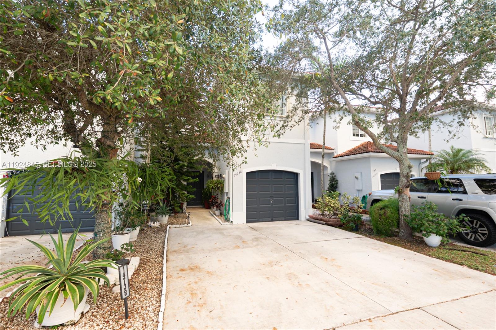 14738 Southwest 9th Lane Miami, FL 33194 - Photo 13 of 31 a view of a white house with a yard and potted plants