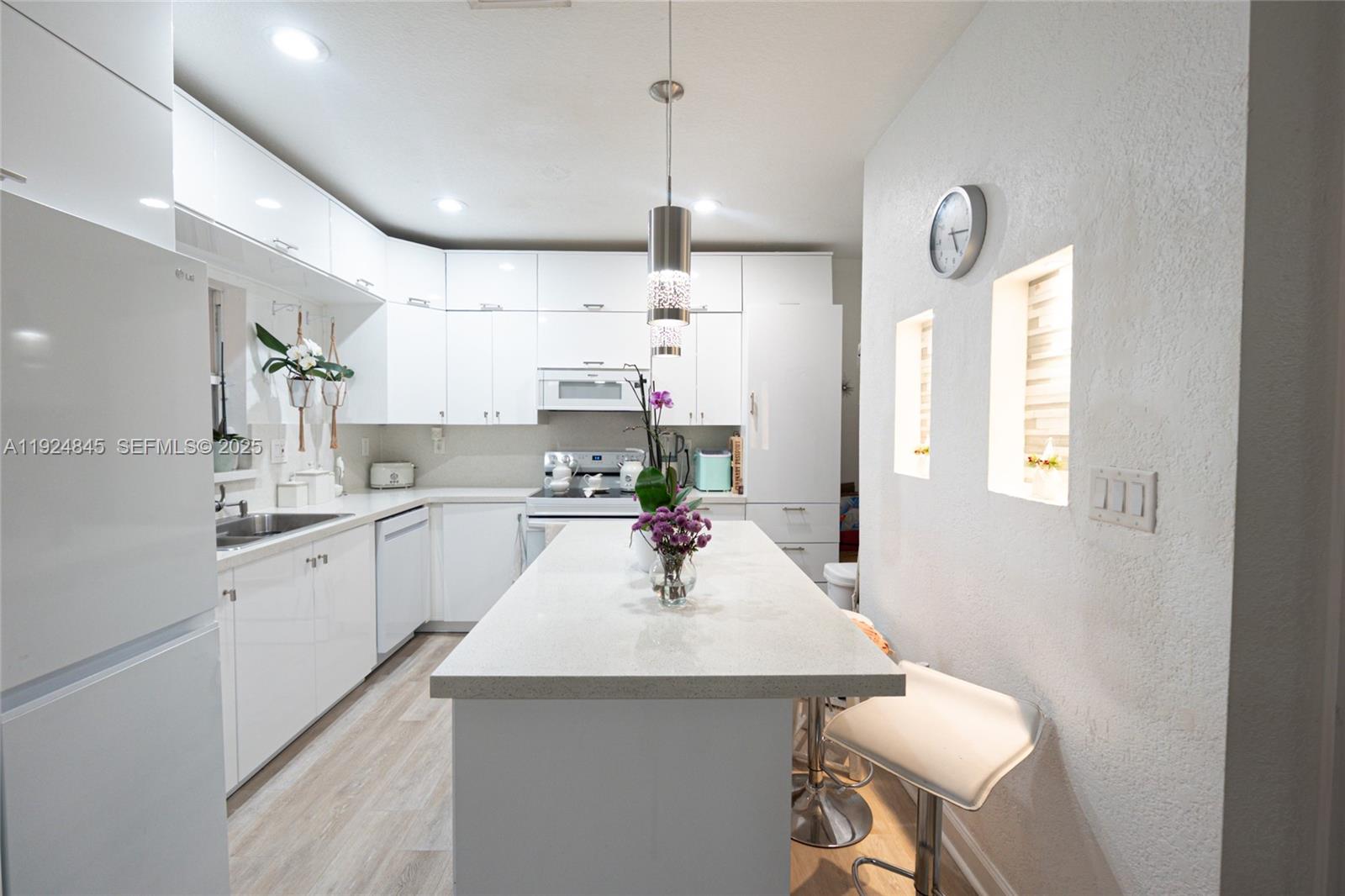 14738 Southwest 9th Lane Miami, FL 33194 - Photo 17 of 31 a kitchen with kitchen island a sink counter space and stainless steel appliances