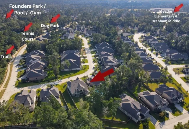 an aerial view of a house with a yard and large trees