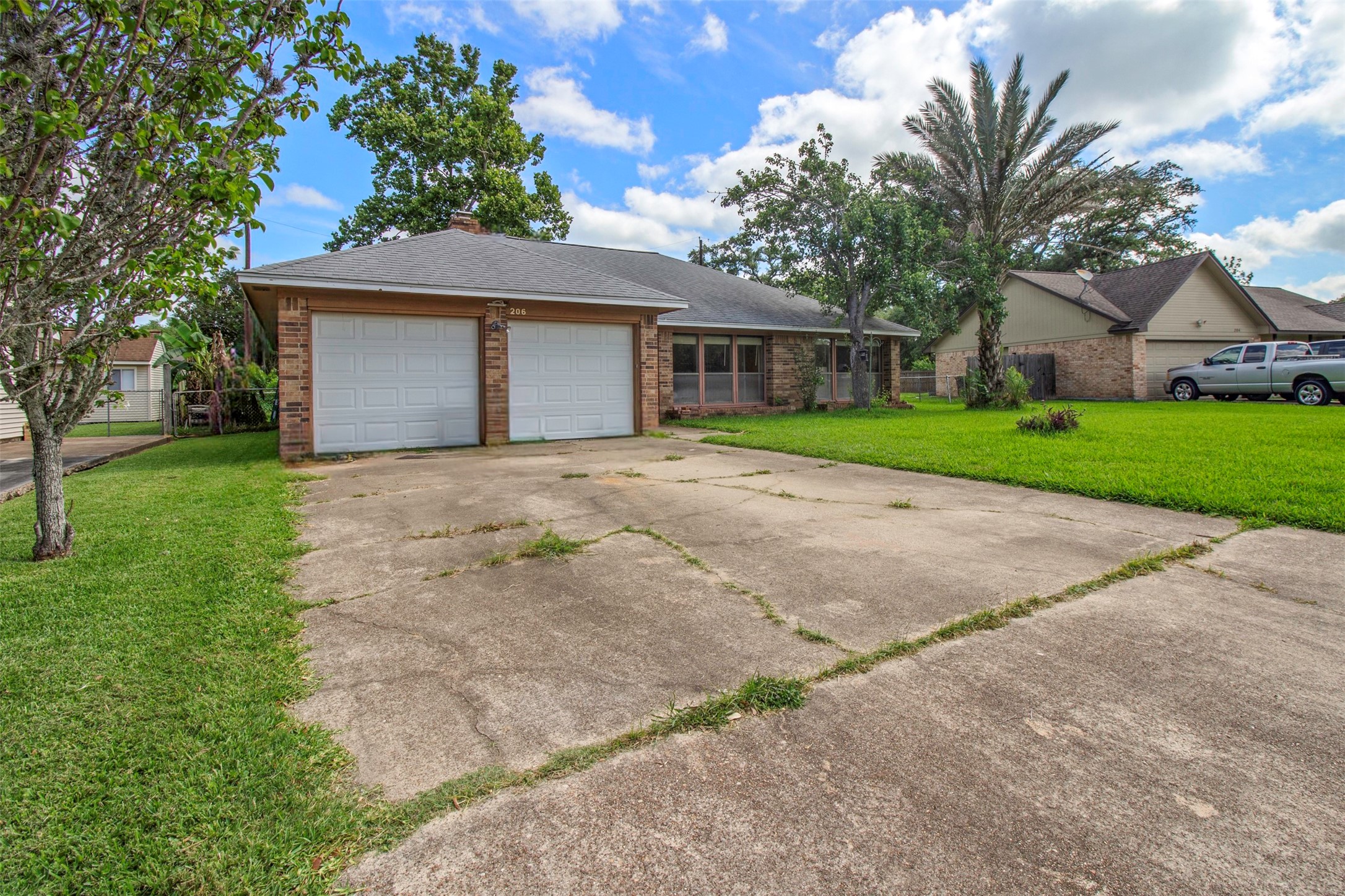 206 Stanford Road Lake Jackson, TX 77566 - Photo 2 of 26 a front view of a house with a yard and garage