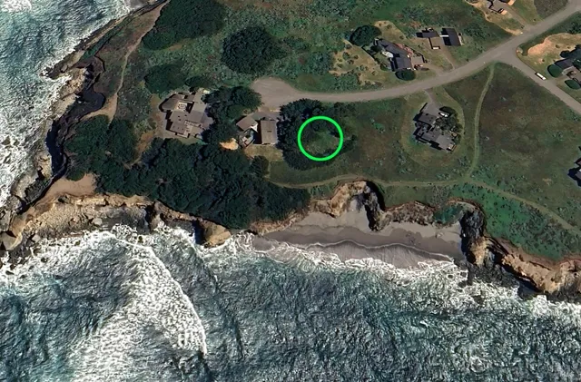 an aerial view of a house with a yard and green space