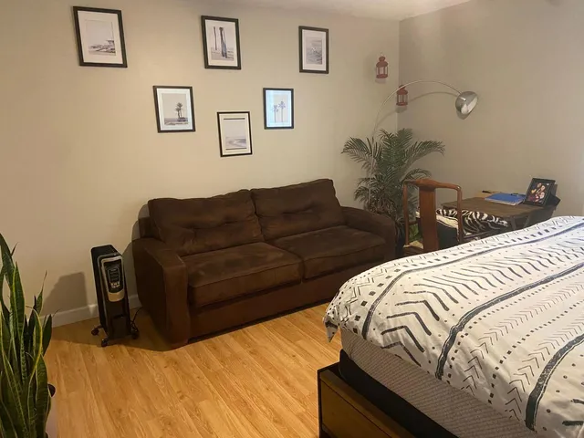 a bedroom with a bed and painting on the wall