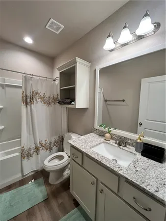 a bathroom with a granite countertop sink toilet and shower