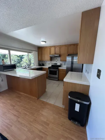 a kitchen with a stove a sink a microwave a counter space and cabinets