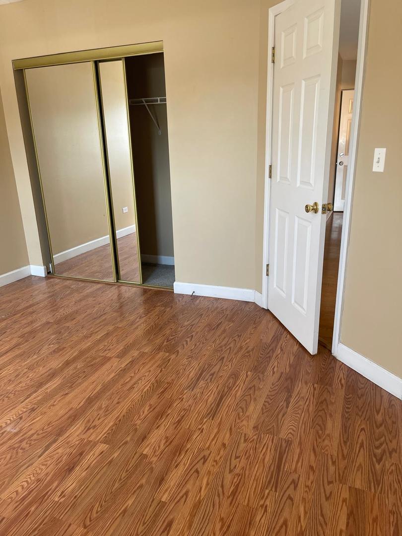 1000 South Lorraine Road, Unit 214 Wheaton, IL 60189 - Photo 2 of 12 an empty room with wooden floor and entrance