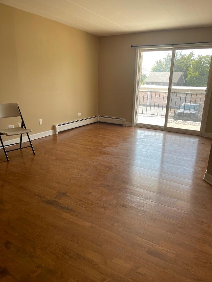 1000 South Lorraine Road, Unit 214 Wheaton, IL 60189 - Photo 7 of 12 wooden floor in an empty room with a window