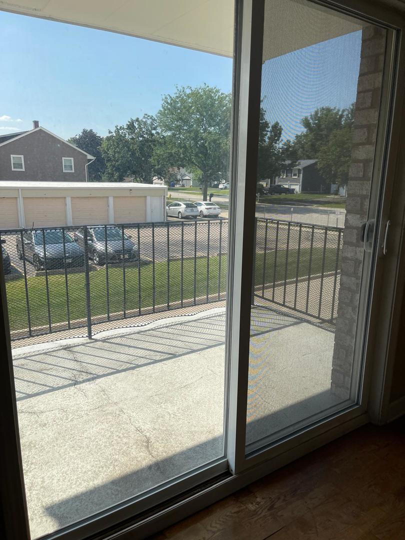 1000 South Lorraine Road, Unit 214 Wheaton, IL 60189 - Photo 8 of 12 a view of a balcony with floor to ceiling windows