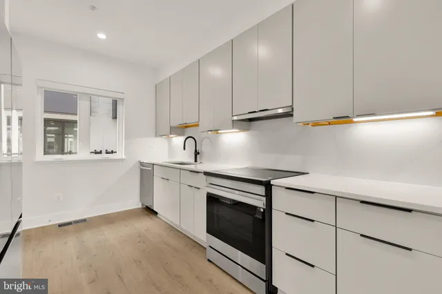 a kitchen with white cabinets and white appliances