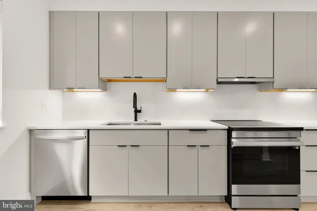 a kitchen with a sink cabinets and stainless steel appliances