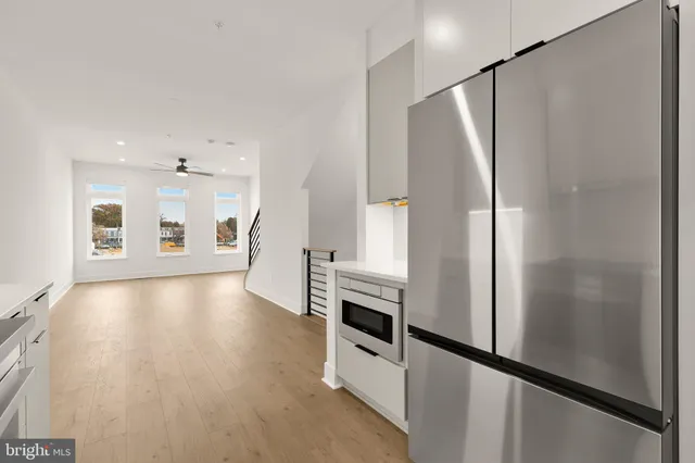 a view of a big room with wooden floor and windows