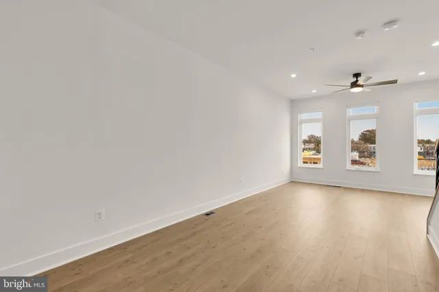an empty room with window and wooden floor