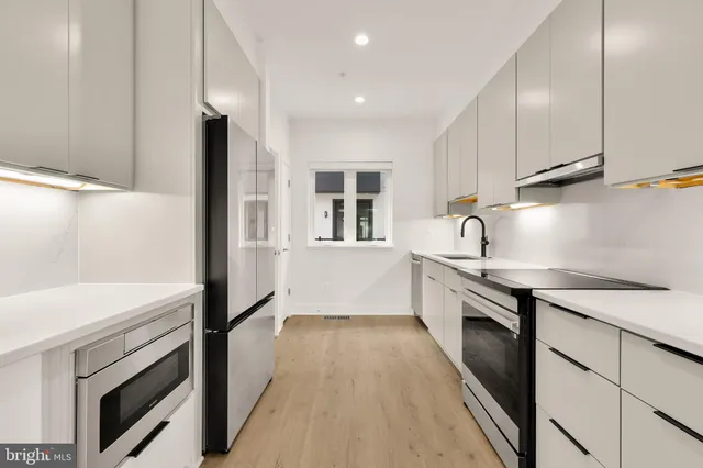 a kitchen with a refrigerator and a stove top oven