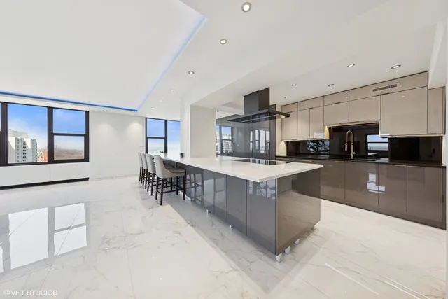 a kitchen with stainless steel appliances kitchen island granite countertop a table and chairs in it