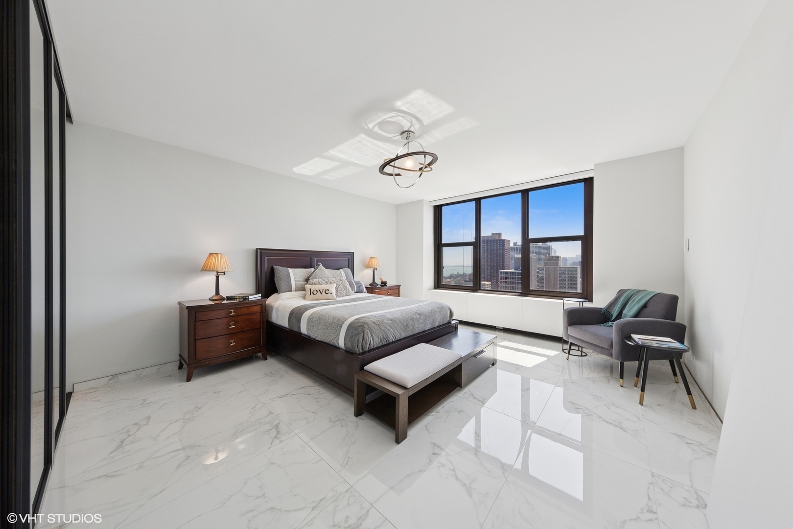 3150 North Lake Shore Drive, Unit 27F Chicago, IL 60657 - Photo 22 of 31 a bedroom with a bed and a chandelier