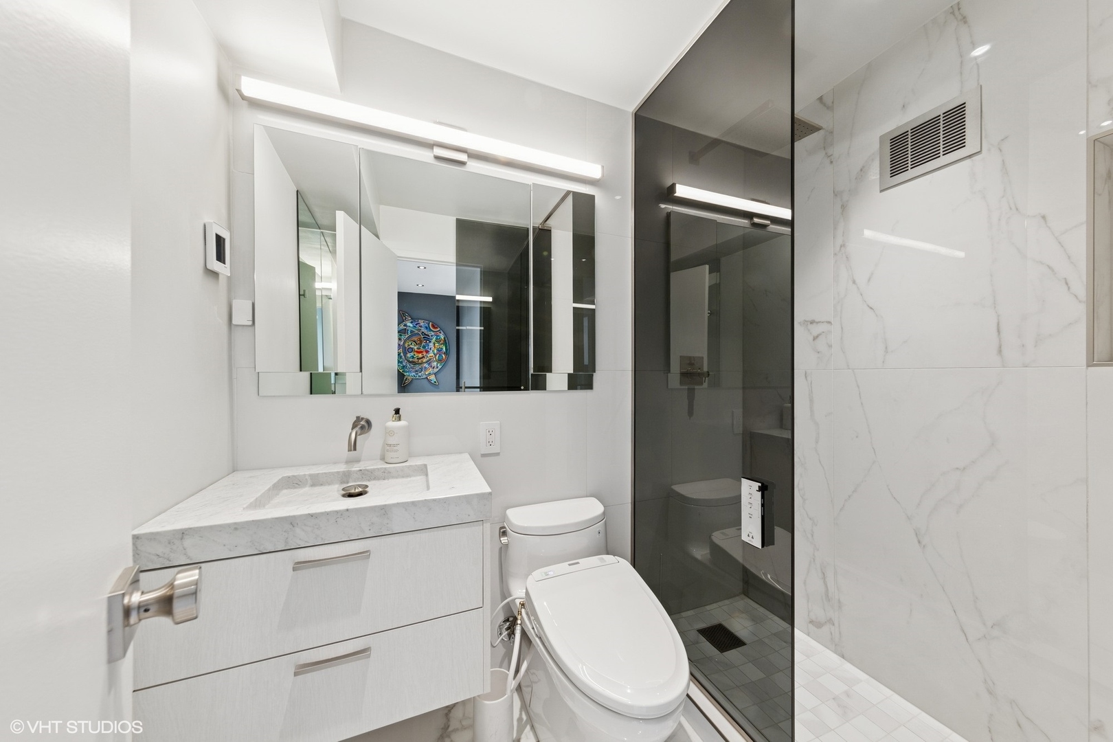 3150 North Lake Shore Drive, Unit 27F Chicago, IL 60657 - Photo 24 of 31 a bathroom with a toilet a sink and mirror