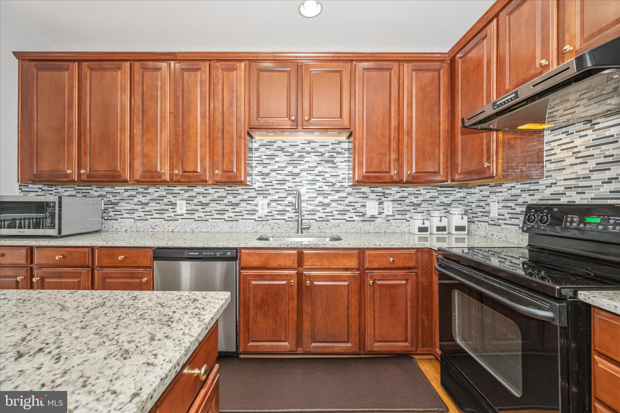 21 Inkberry Circle Gaithersburg, MD 20877 - Photo 19 of 51 a kitchen with stainless steel appliances granite countertop wooden cabinets a stove top oven