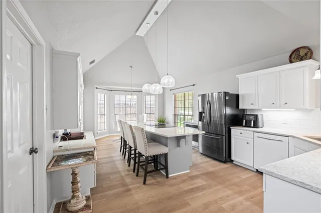 a kitchen with a refrigerator a stove a dining table and chairs