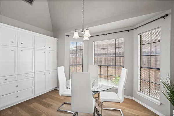 a view of a dining room with furniture large windows and wooden floor
