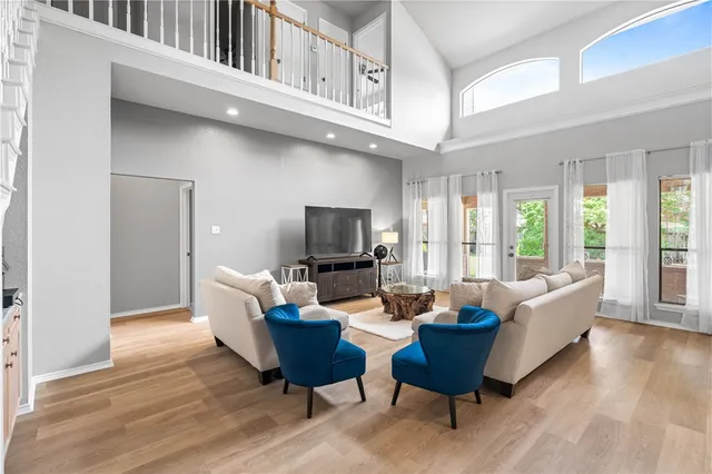 a living room with furniture a flat screen tv and a large window