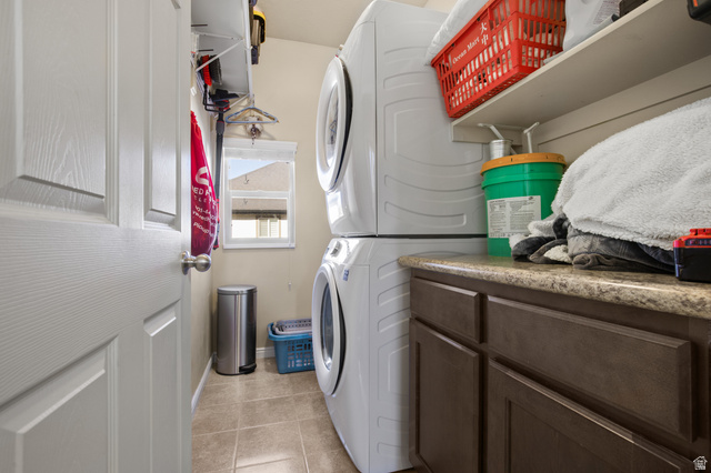 2005 Redtail Way Layton, UT 84040 - Photo 9 of 37 Laundry area featuring stacked appliances, built-in shelving, a window, brown cabinetry, and a countertop