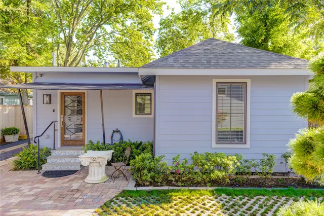 a view of a house with swimming pool lawn chairs and a potted plant