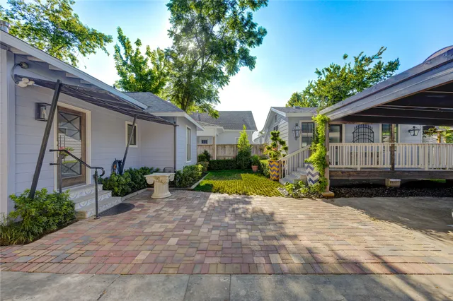 a view of a house with a yard and potted plants
