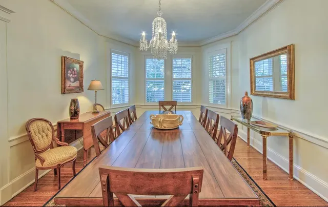 a view of a dining room with furniture a chandelier and wooden floor