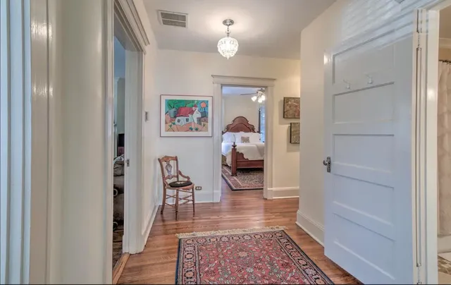 a view of a hallway to a livingroom with furniture and wooden floor