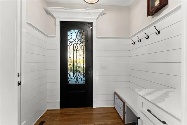 a view of a hallway with wooden floor and staircase