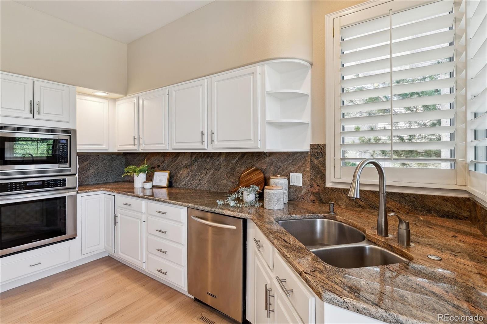72 Falcon Hills Drive Highlands Ranch, CO 80126 - Photo 14 of 49 a kitchen with granite countertop a sink a stove and cabinets