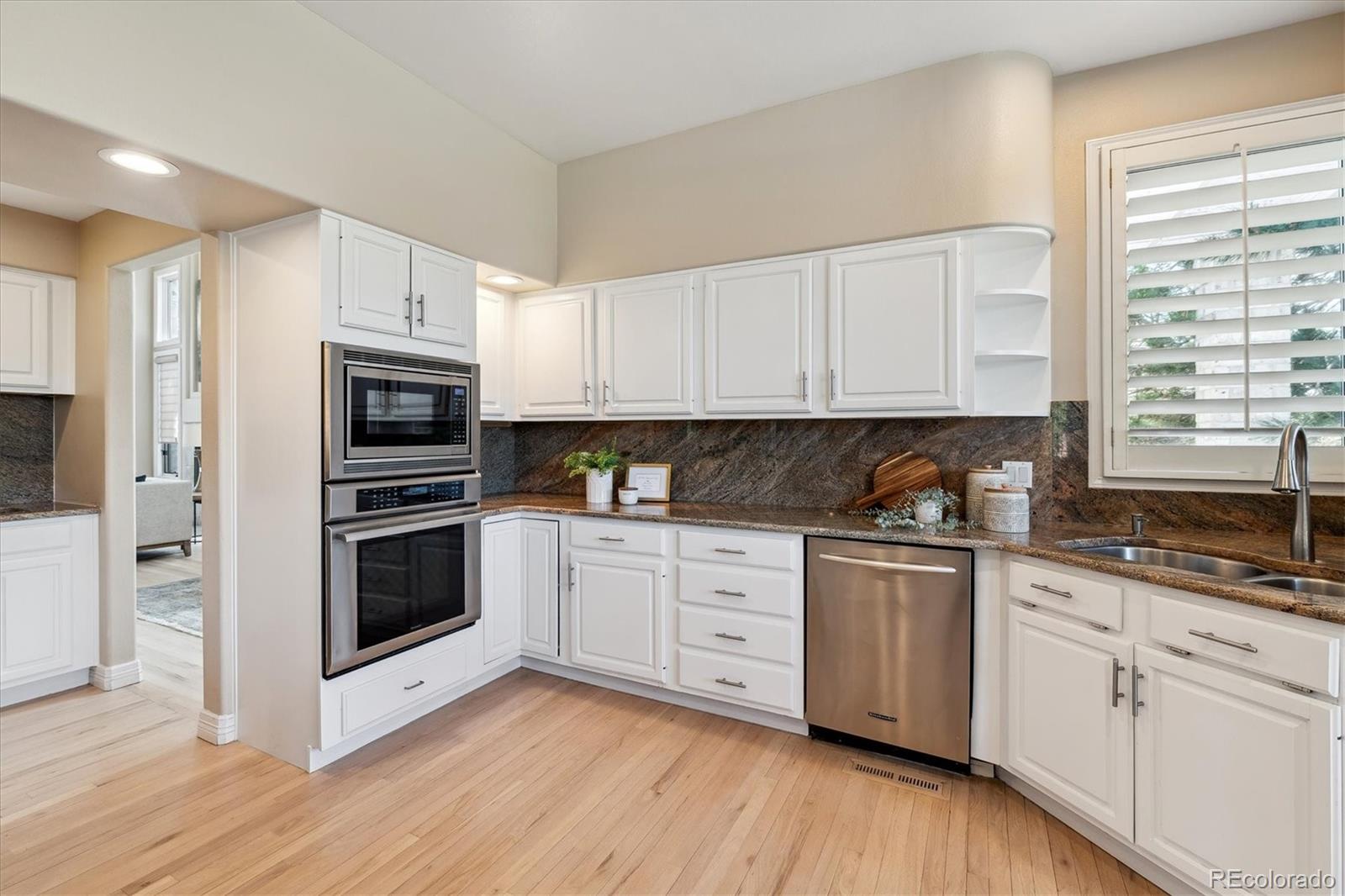 72 Falcon Hills Drive Highlands Ranch, CO 80126 - Photo 15 of 49 a kitchen with stainless steel appliances granite countertop a stove a sink and white cabinets