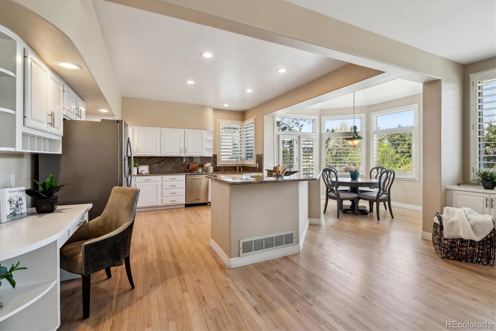 72 Falcon Hills Drive Highlands Ranch, CO 80126 - Photo 16 of 49 a kitchen with stainless steel appliances granite countertop dining table chairs refrigerator and sink