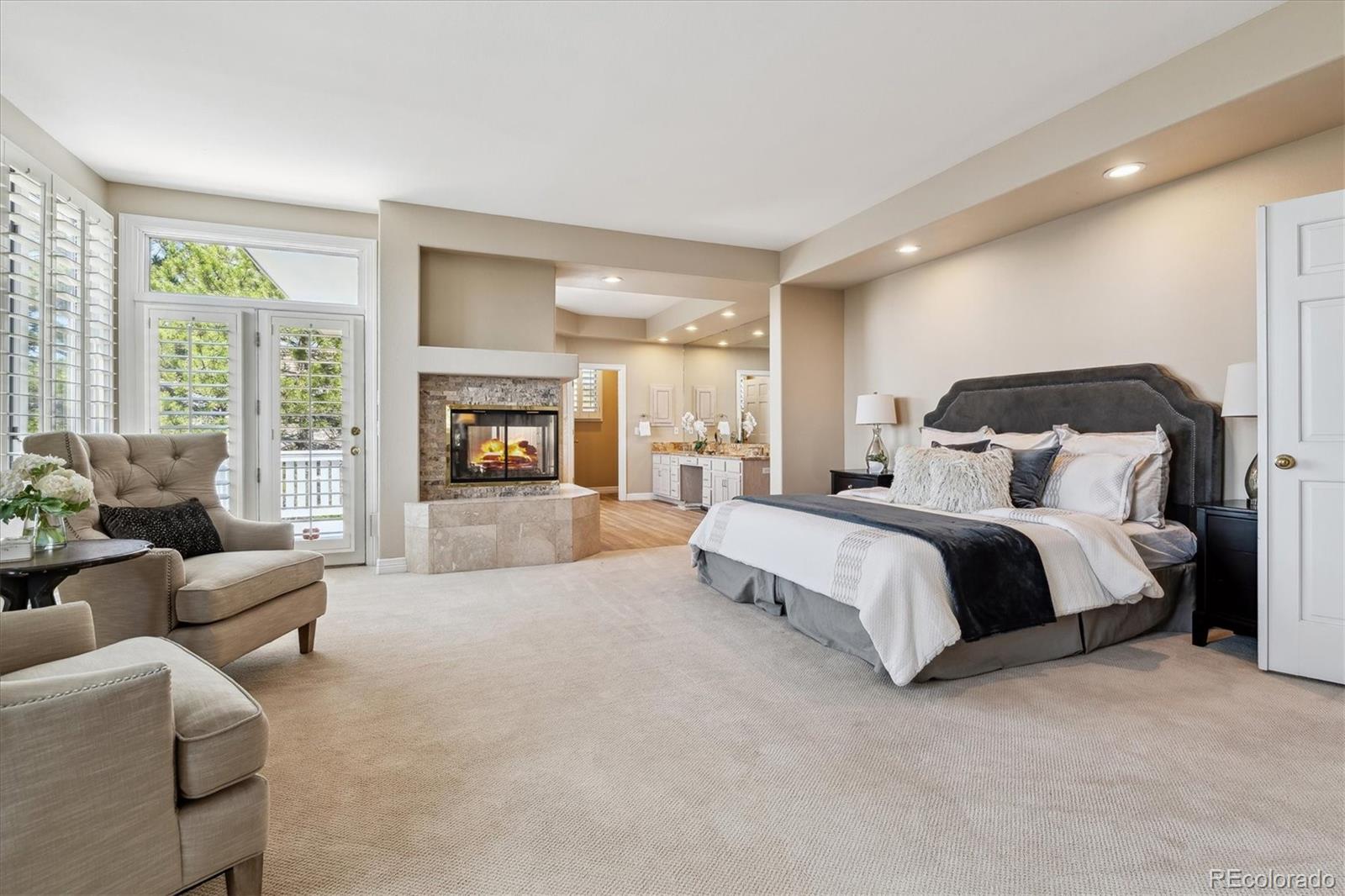 72 Falcon Hills Drive Highlands Ranch, CO 80126 - Photo 34 of 49 a spacious bedroom with a large bed and a fireplace