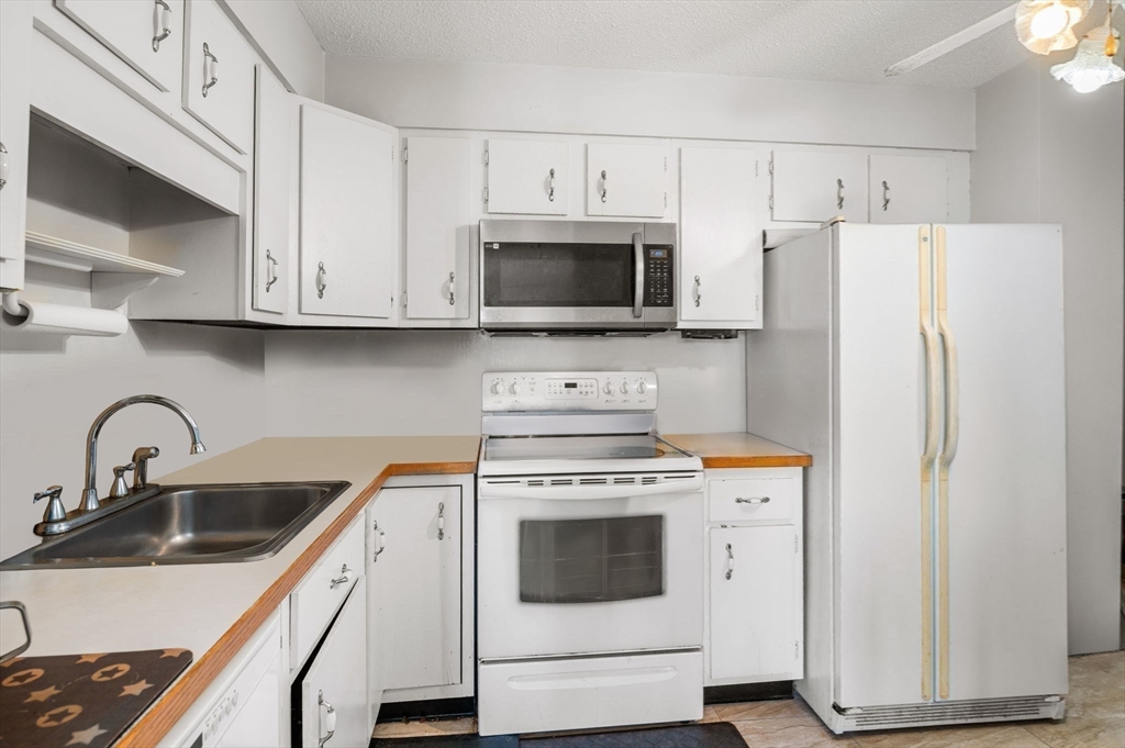 1004 Paradise Road, Unit PHJ Swampscott, MA 01907 - Photo 12 of 29 a kitchen with cabinets stainless steel appliances and a sink