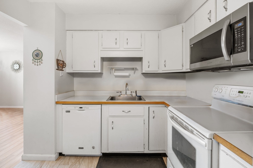 1004 Paradise Road, Unit PHJ Swampscott, MA 01907 - Photo 13 of 29 a kitchen with granite countertop white cabinets and sink
