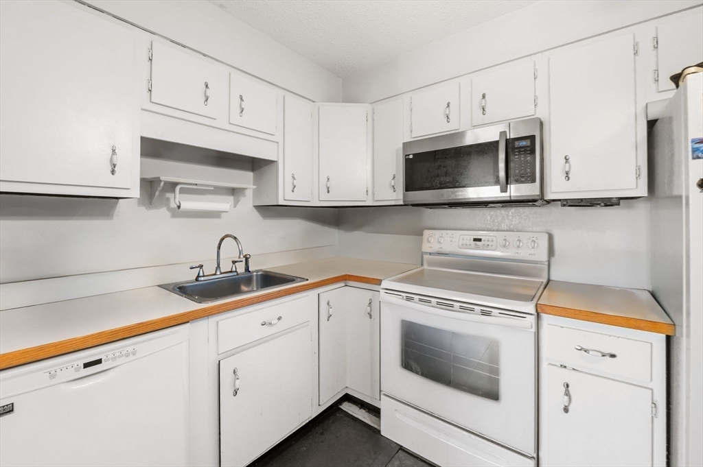 1004 Paradise Road, Unit PHJ Swampscott, MA 01907 - Photo 14 of 29 a kitchen with cabinets stainless steel appliances a sink and a microwave