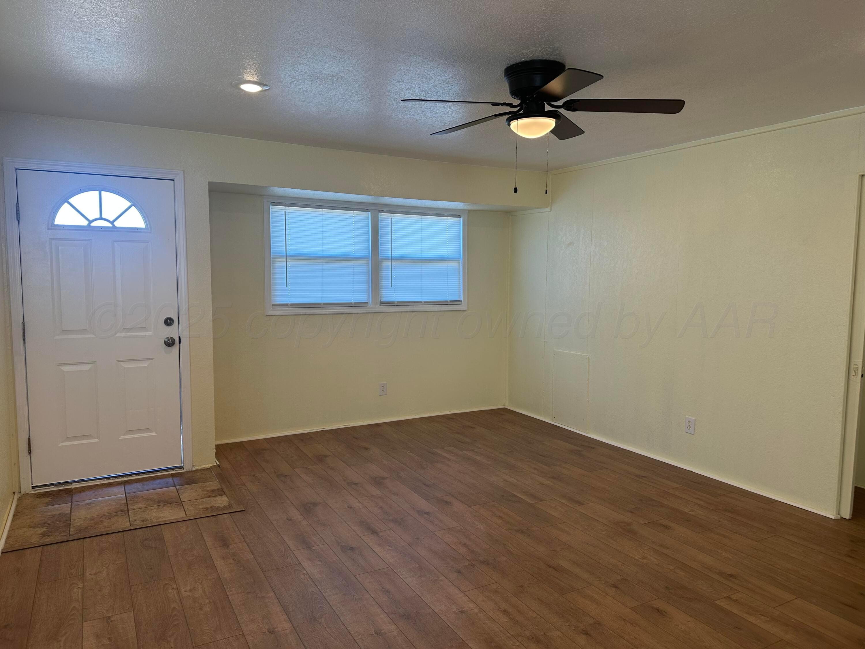 1012 Harper Street Amarillo, TX 79107 - Photo 3 of 22 an empty room with wooden floor and a ceiling fan