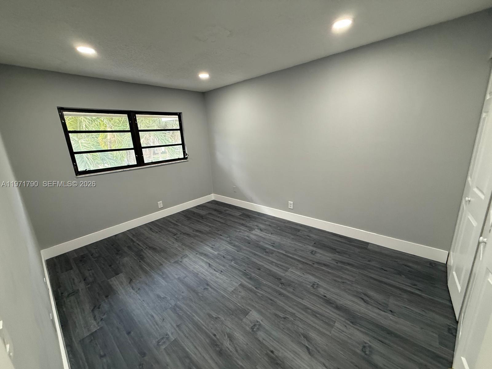 2700 North 34th Avenue, Unit I Hollywood, FL 33021 - Photo 17 of 35 an empty room with wooden floor and windows