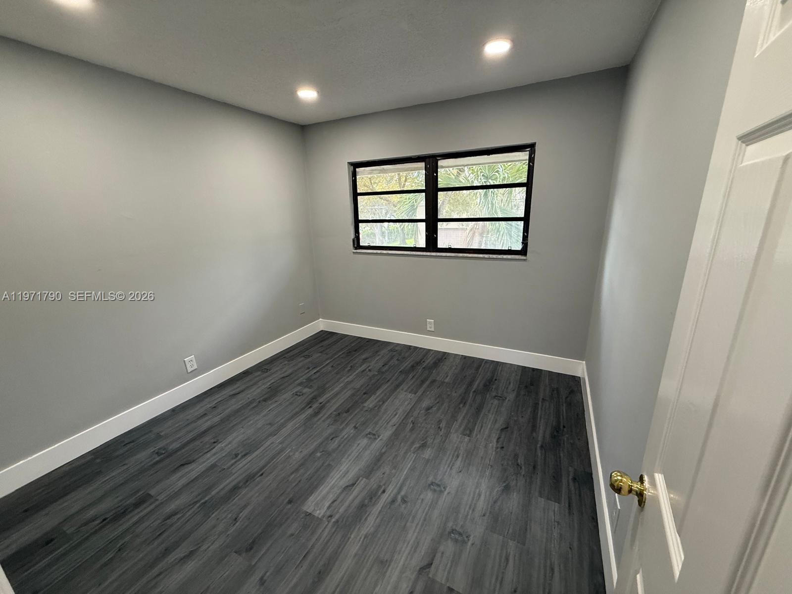 2700 North 34th Avenue, Unit I Hollywood, FL 33021 - Photo 19 of 35 an empty room with wooden floor and windows