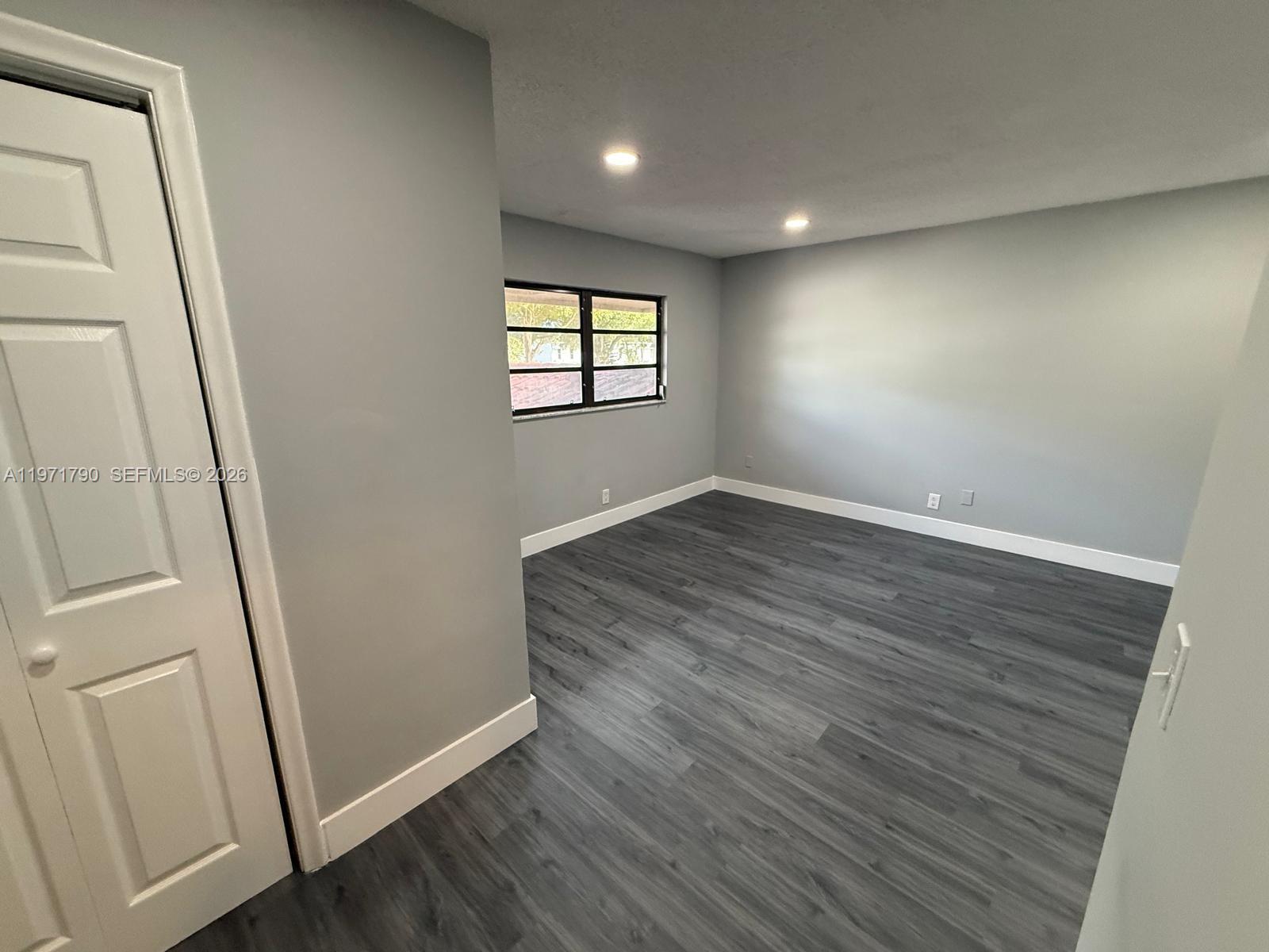 2700 North 34th Avenue, Unit I Hollywood, FL 33021 - Photo 27 of 35 an empty room with wooden floor and windows