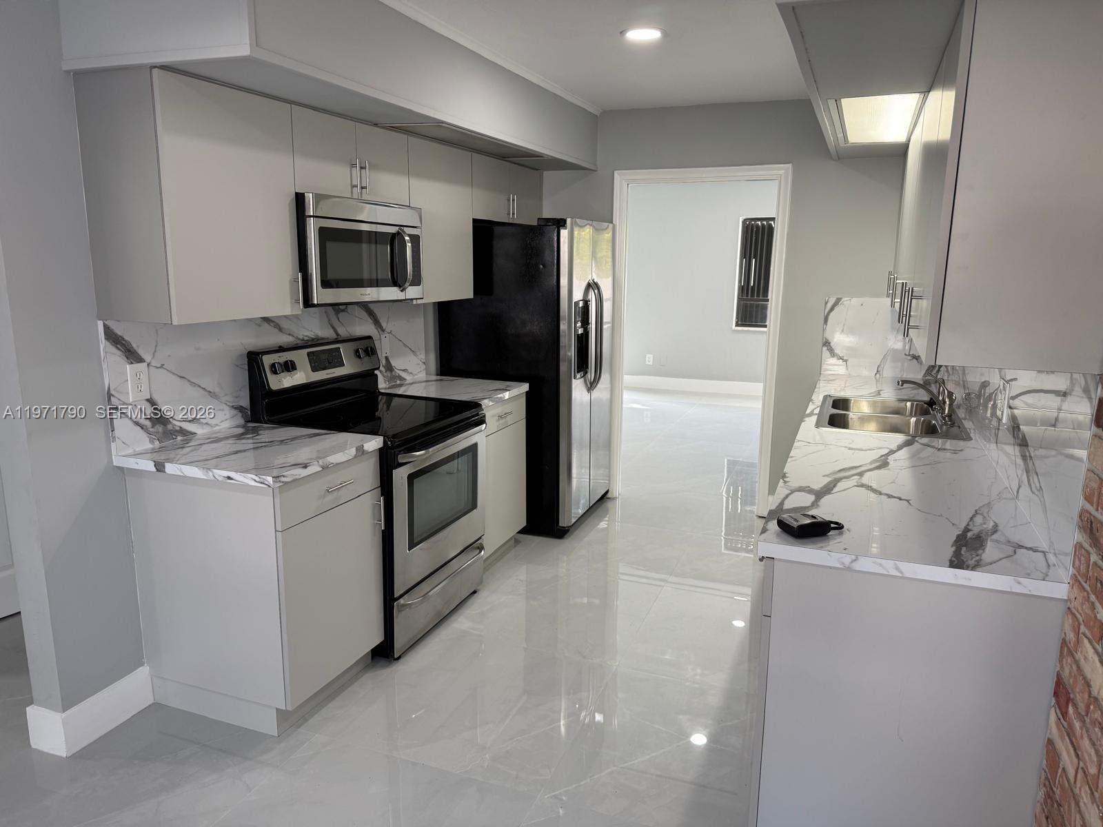 2700 North 34th Avenue, Unit I Hollywood, FL 33021 - Photo 5 of 35 a kitchen with a sink stainless steel appliances and cabinets