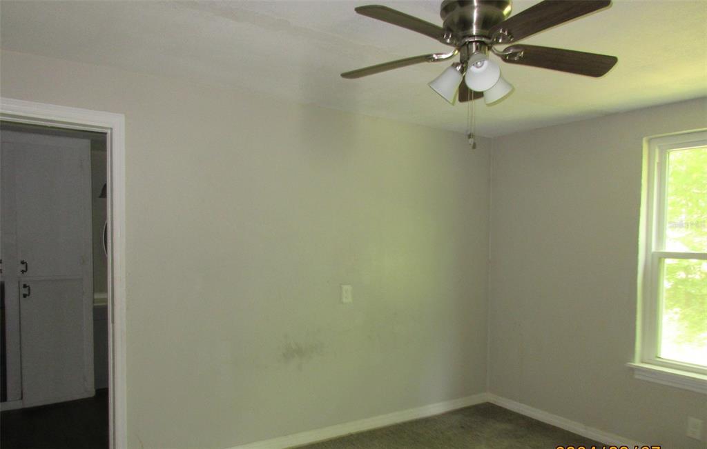 214 West Dade Avenue Bushnell, FL 33513 - Photo 12 of 13 an empty room with a window and a fan