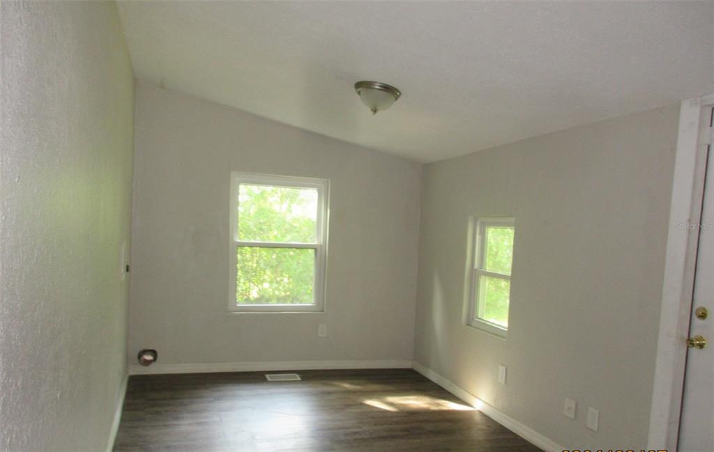 214 West Dade Avenue Bushnell, FL 33513 - Photo 13 of 13 a view of an empty room with wooden floor and a window