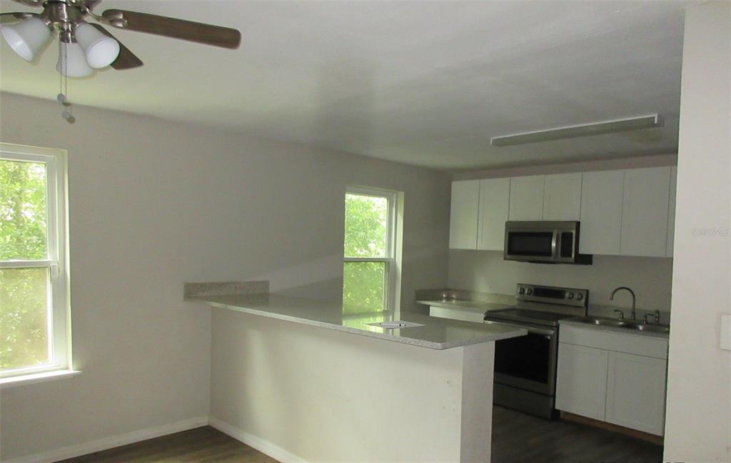 214 West Dade Avenue Bushnell, FL 33513 - Photo 3 of 13 a kitchen with a refrigerator and a stove top oven