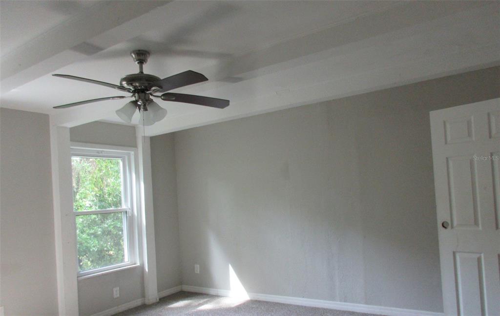 214 West Dade Avenue Bushnell, FL 33513 - Photo 6 of 13 an empty room with a window and a fan